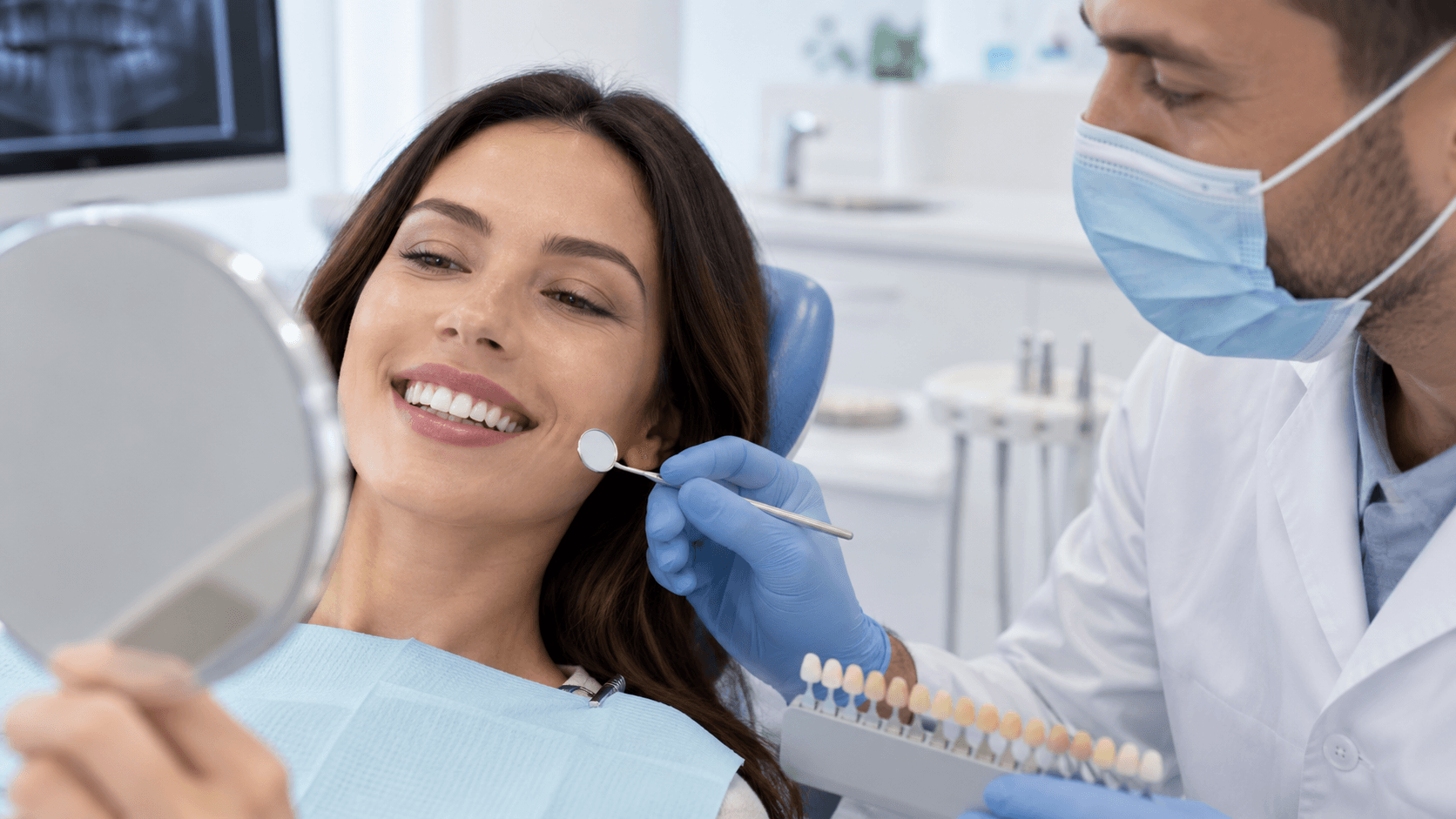 Patient reviewing a brighter smile with a dental professional and shade guide